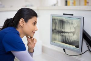 a dental assistant examining an x-ray result