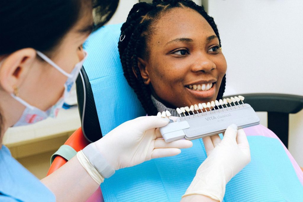 Smiling patient speaking to empathetic dental assistant with good listening skills