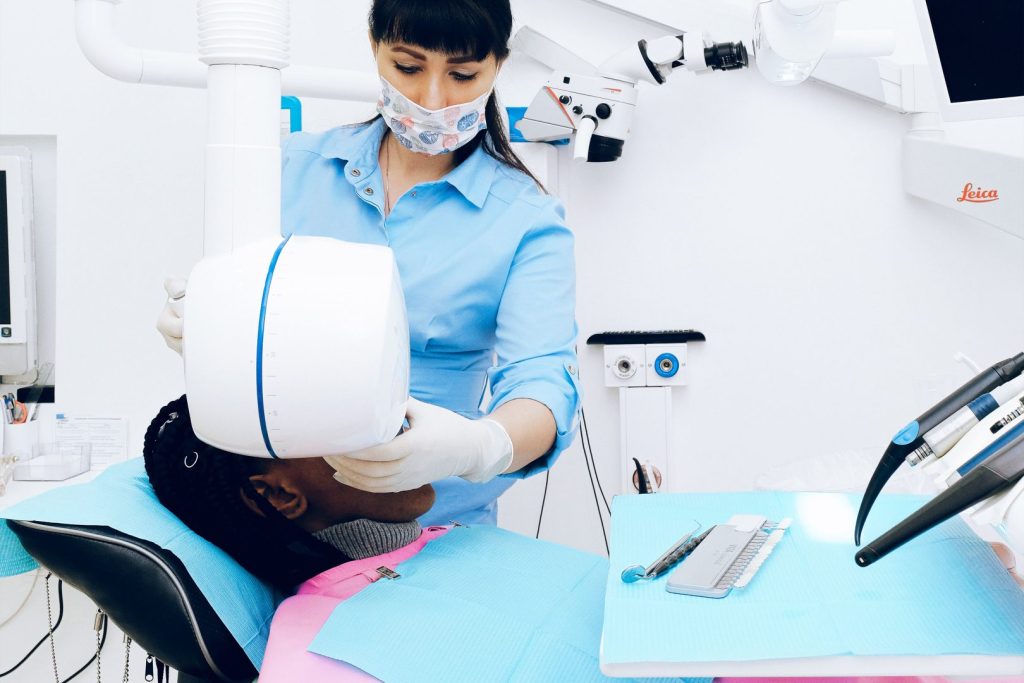 Dental assistant taking x-rays of patient during appointment
