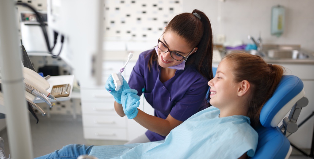 Dental assistant educating patient during appointment