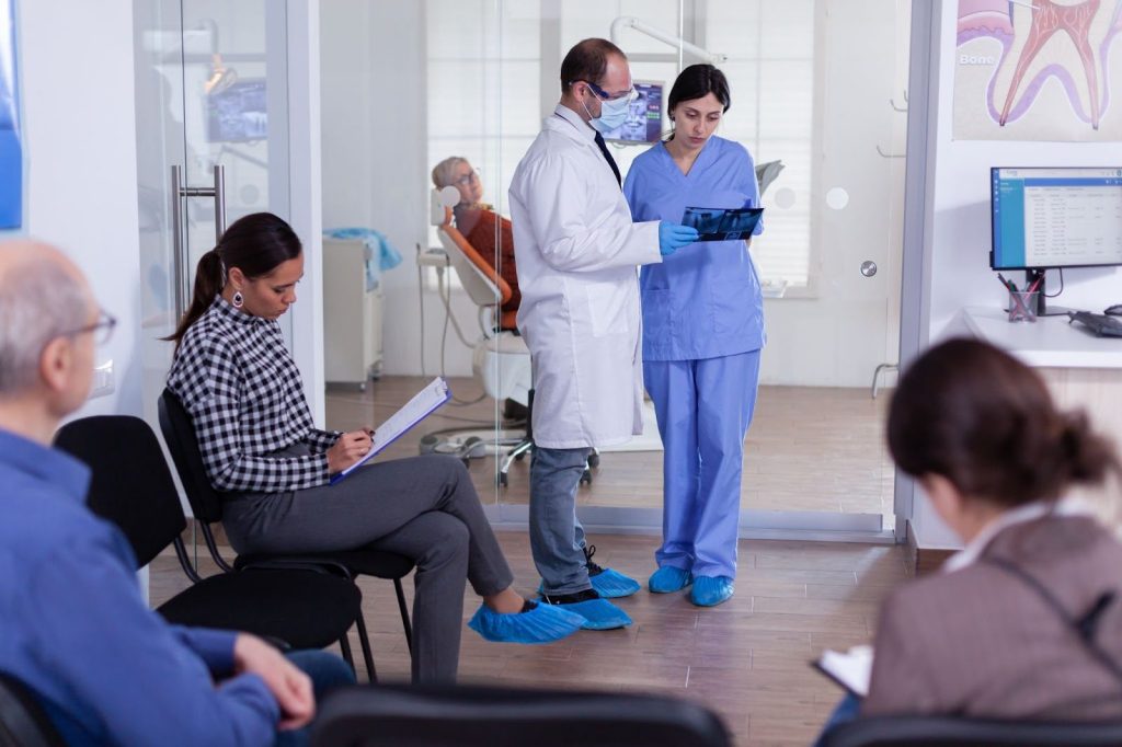 Dental assistant talking to dentist in practice to clarify potential misunderstanding