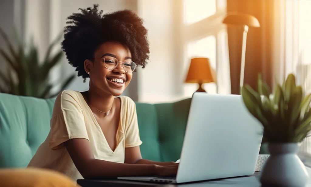 Woman sitting on couch researching dental programs on laptop