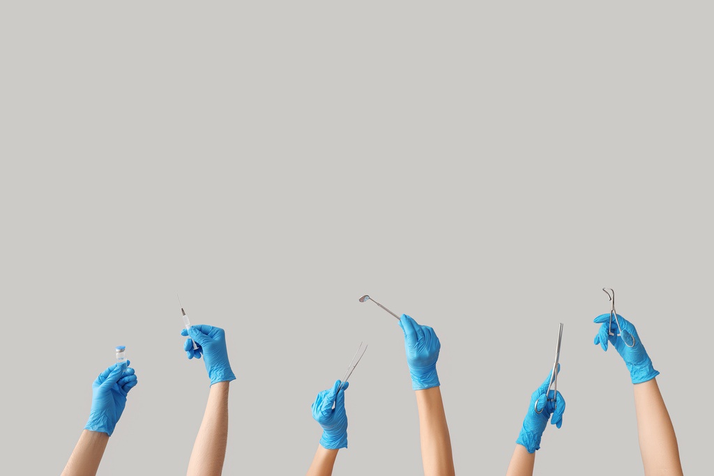 Hands of dental assistants holding instruments up in celebration to represent optimistic job prospects