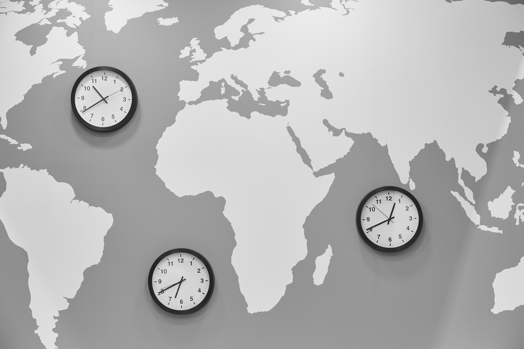 World map with clocks representing different time zones as potential barrier for international dental assisting students