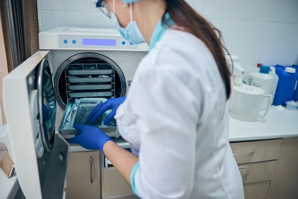 Steritech taking instruments out of autoclave in dental practice