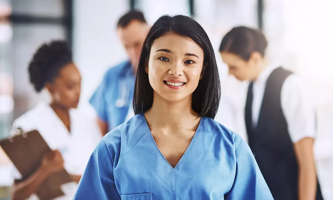 Entry level dental assistant smiling in blue scrub