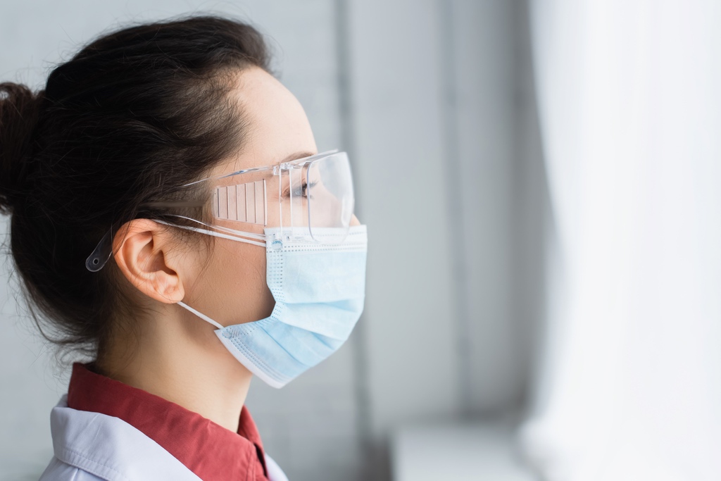 Dental assistant at work with mask and safety glasses
