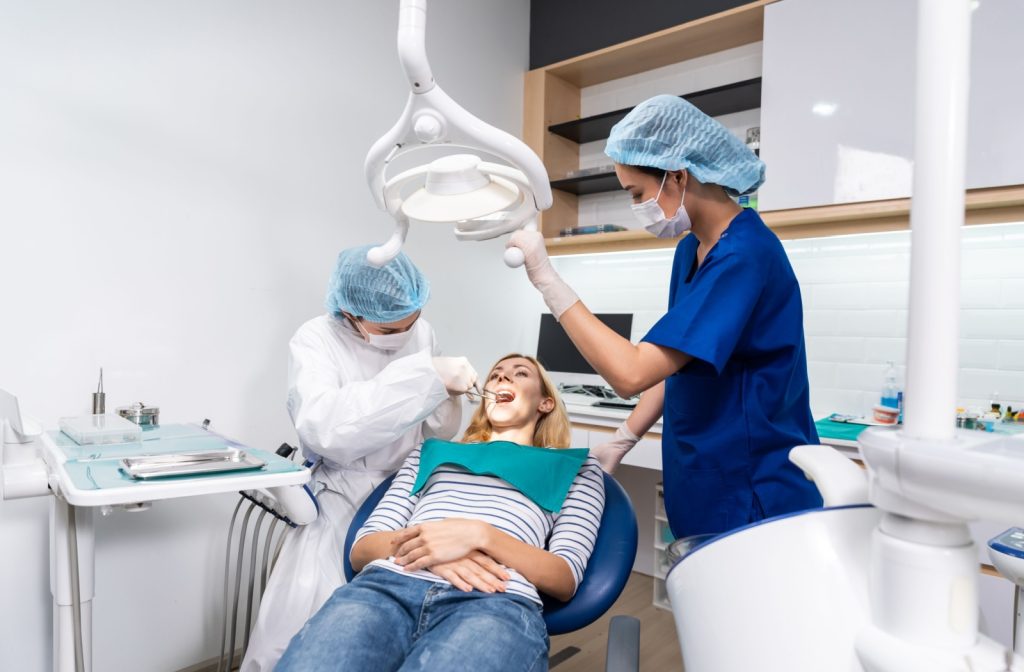 A dental assistant supporting the dentist during a procedure.